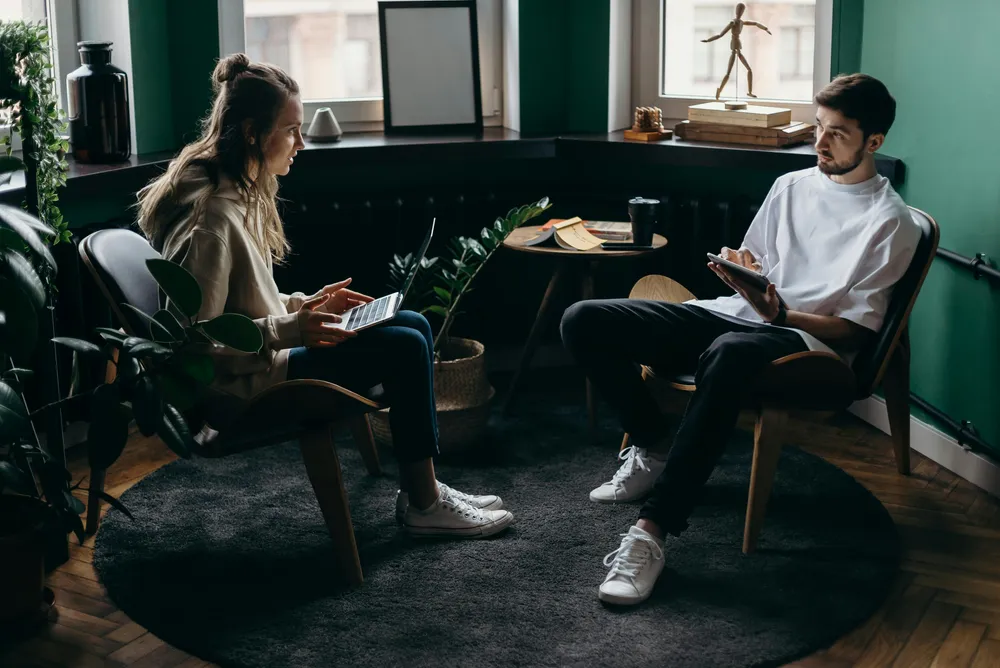 Ein Mann und eine Frau sitzen in einem Studio und diskutieren